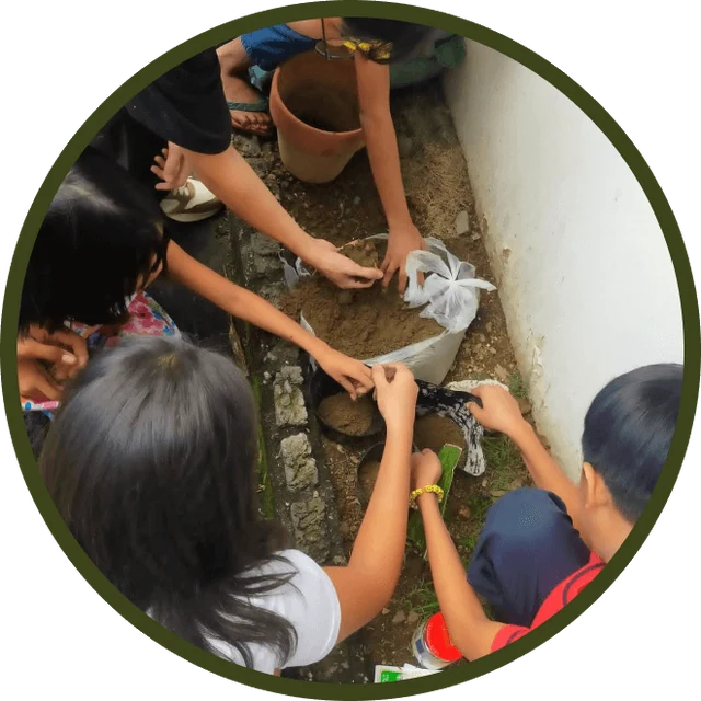 Children at Right Start planting seedlings along a garden bed